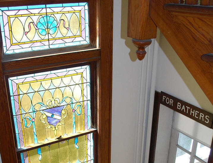 Stairs from the first to the second floor ...original stained glass window